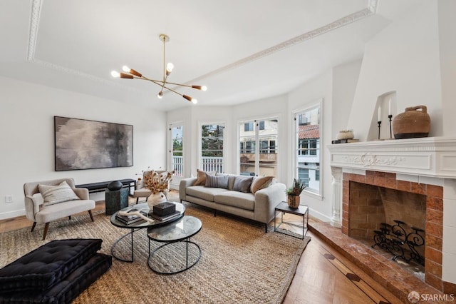 living room with a notable chandelier, hardwood / wood-style flooring, and a fireplace