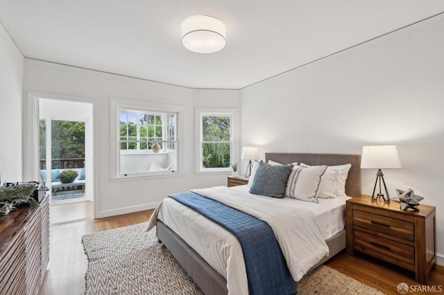 bedroom featuring access to exterior and hardwood / wood-style floors