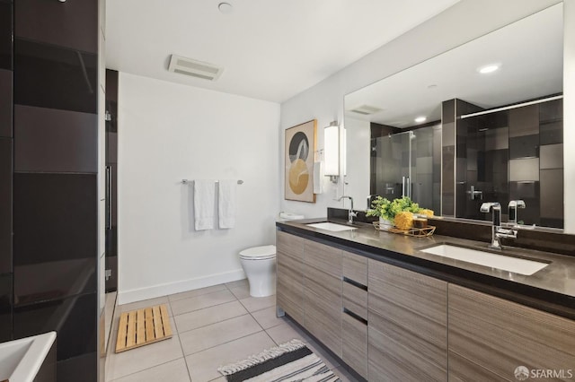 bathroom with tile patterned flooring, vanity, an enclosed shower, and toilet