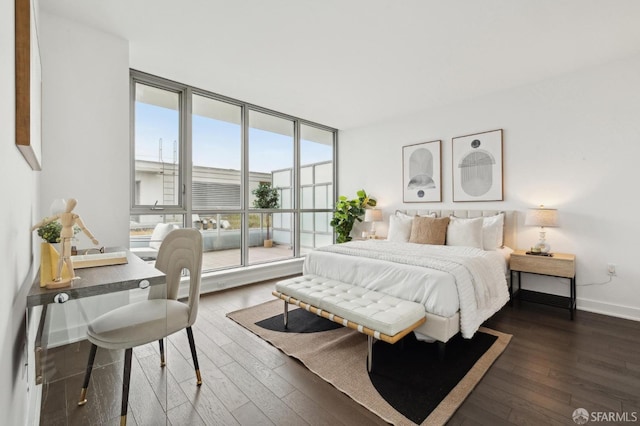 bedroom featuring expansive windows and dark wood-type flooring