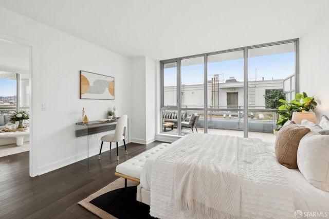 bedroom featuring multiple windows, expansive windows, and dark wood-type flooring