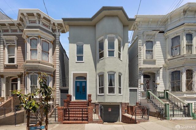 3470 20th St Unit 2, San Francisco, CA 94110 - view of front of house with entry steps, stucco siding, and a garage