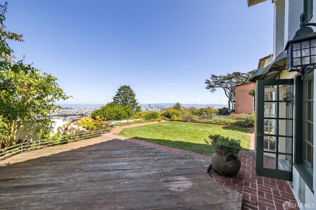 wooden terrace featuring fence and a lawn