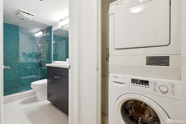 clothes washing area featuring stacked washer and clothes dryer and light tile patterned floors