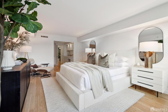 bedroom featuring light hardwood / wood-style floors and connected bathroom