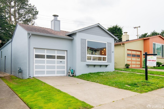 view of front facade featuring concrete driveway, a chimney, an attached garage, a front yard, and stucco siding