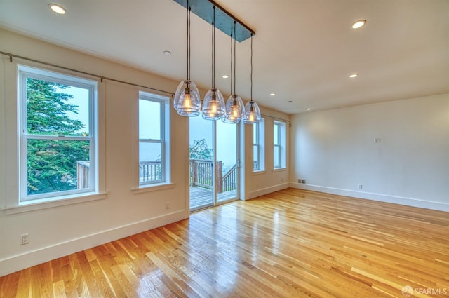 unfurnished dining area with light hardwood / wood-style floors and a wealth of natural light