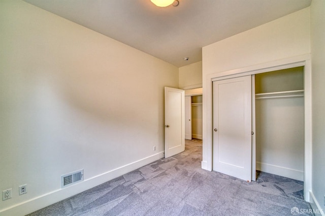 unfurnished bedroom featuring a closet and light carpet