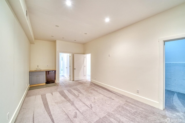 carpeted empty room featuring indoor wet bar