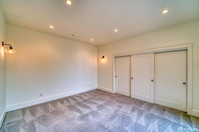 unfurnished bedroom with light colored carpet and a closet