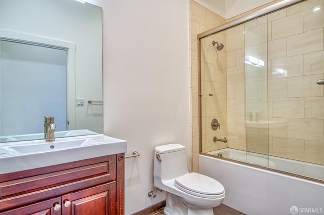 full bathroom with bath / shower combo with glass door, vanity, and toilet