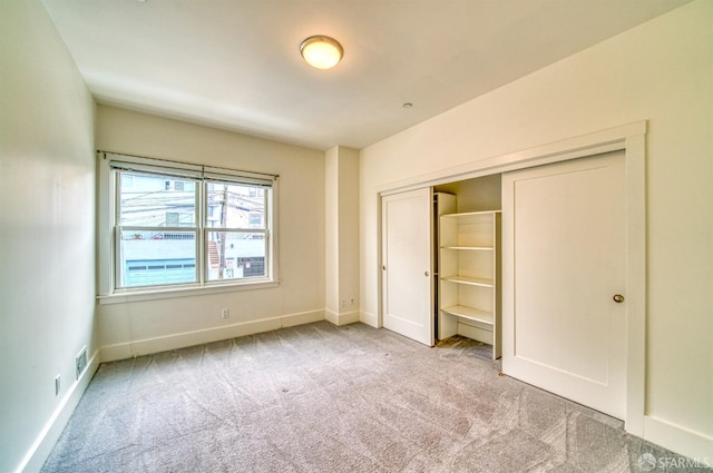 unfurnished bedroom featuring light colored carpet and a closet