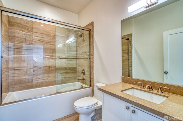 full bathroom featuring shower / bath combination with glass door, toilet, and vanity