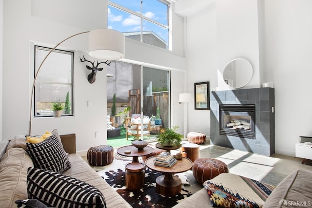 carpeted living room with a tile fireplace and a high ceiling