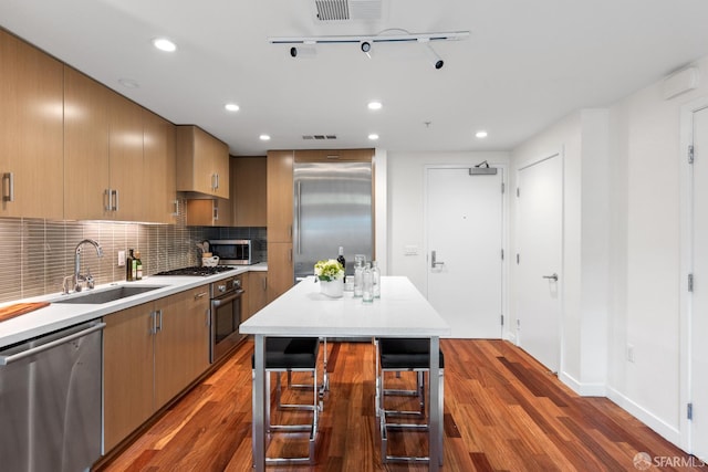 2655 Bush St Unit 119, San Francisco, CA 94115 - kitchen featuring appliances with stainless steel finishes, dark wood finished floors, light countertops, backsplash, and recessed lighting