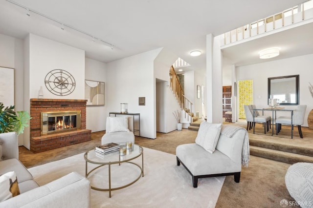 living room featuring light colored carpet, a fireplace, and track lighting