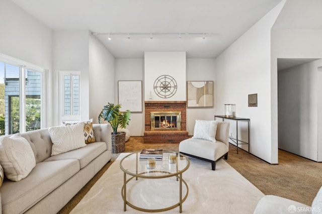 carpeted living room with track lighting and a fireplace