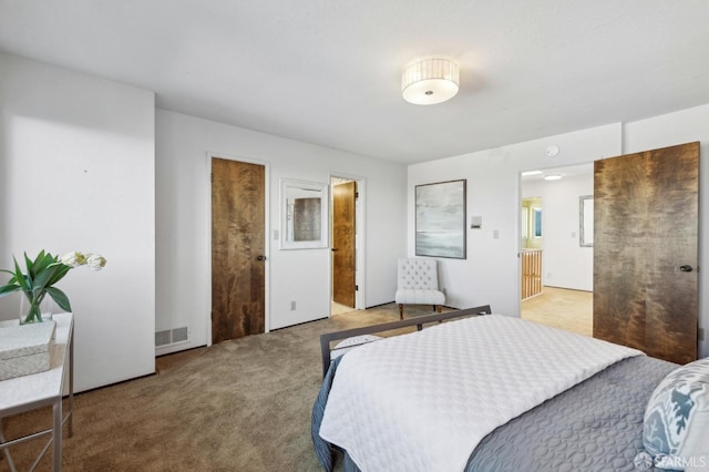 bedroom featuring connected bathroom and light colored carpet