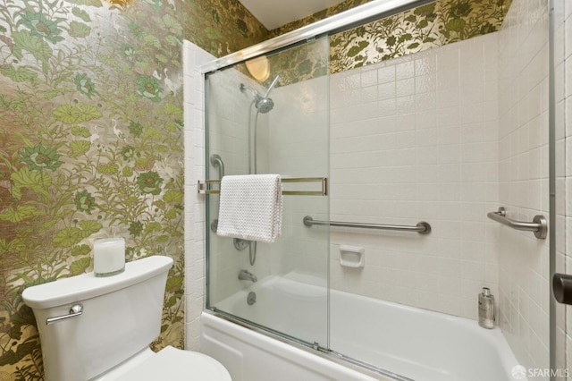 bathroom featuring bath / shower combo with glass door and toilet