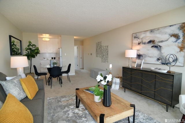 living area with light carpet and a textured ceiling