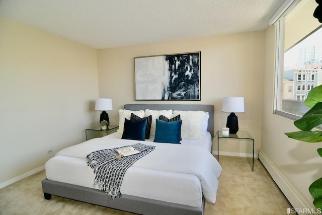 bedroom with carpet, baseboards, baseboard heating, and a textured ceiling