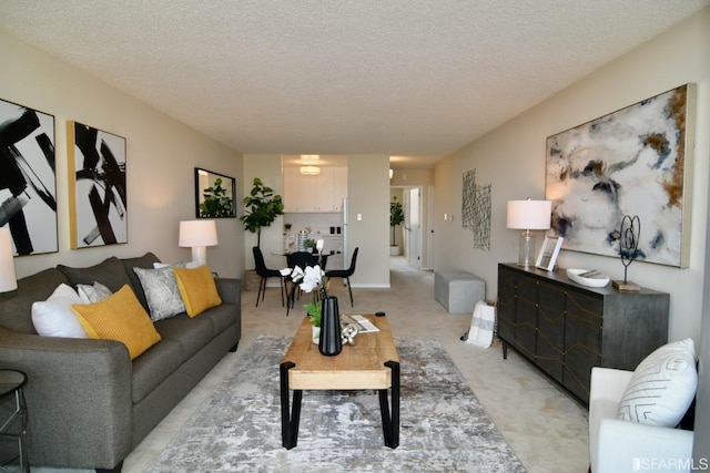 living area featuring light carpet and a textured ceiling