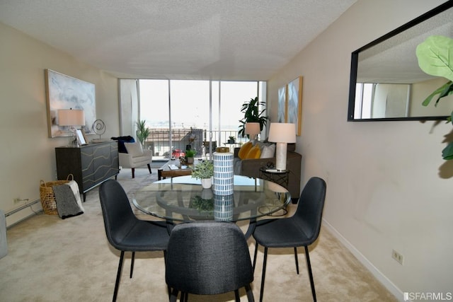 dining space with a wall of windows, carpet flooring, a textured ceiling, and baseboards