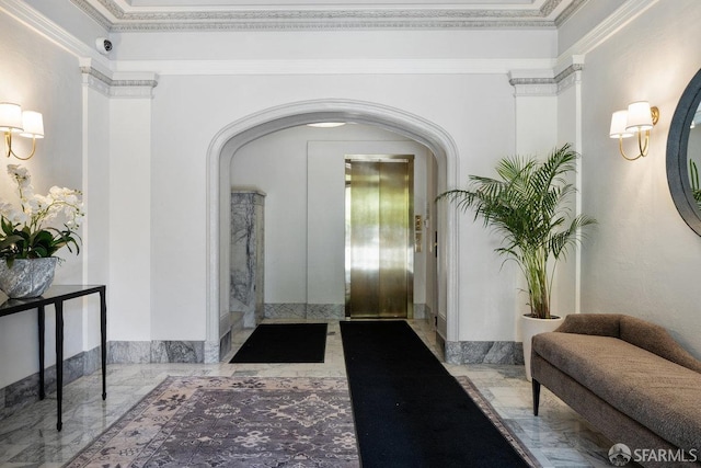 interior space featuring marble finish floor, crown molding, arched walkways, and elevator