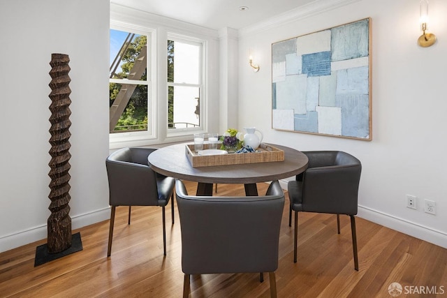 dining area with ornamental molding, wood finished floors, and baseboards