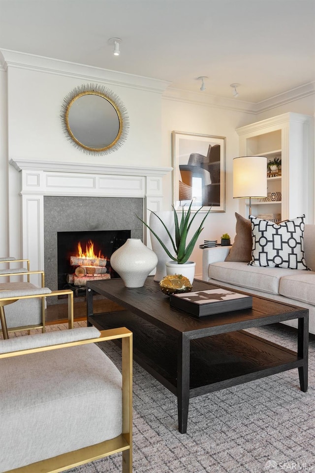 living area with crown molding and a lit fireplace