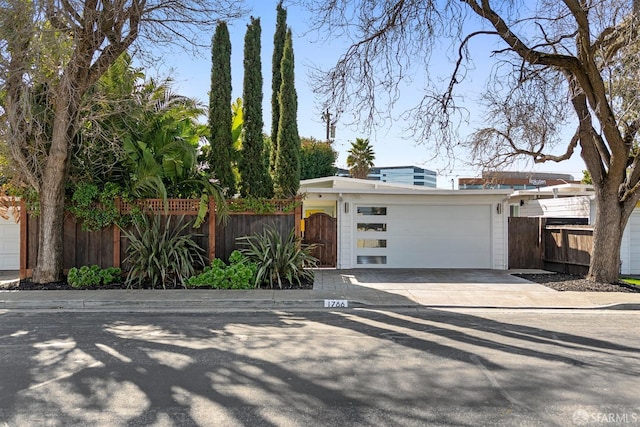 view of front of home featuring a garage, a gate, fence, and driveway