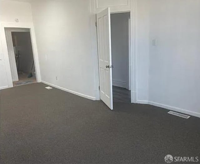 unfurnished room with baseboards and visible vents