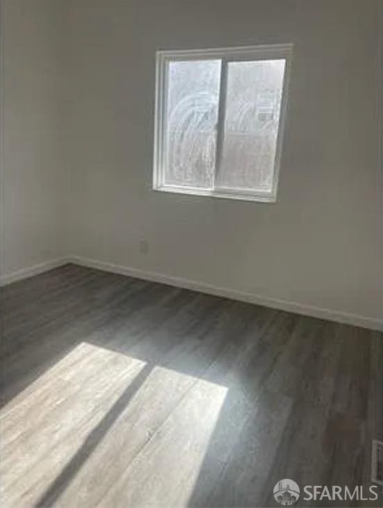 empty room with baseboards and wood finished floors