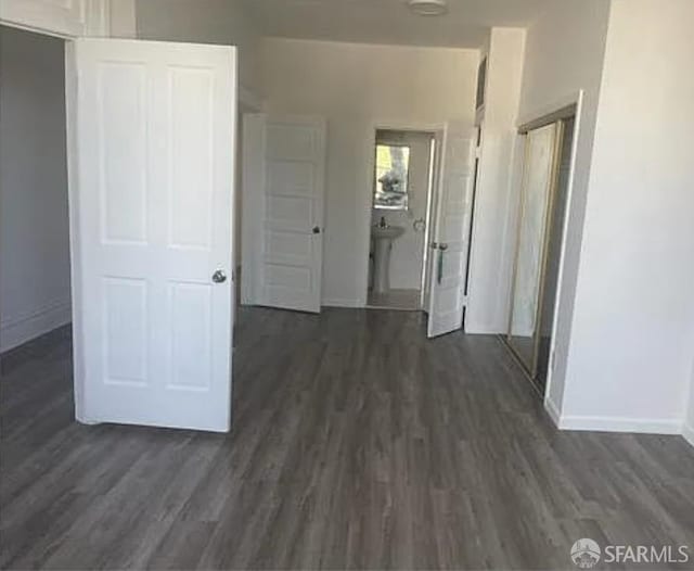 hallway featuring dark wood-style floors and baseboards