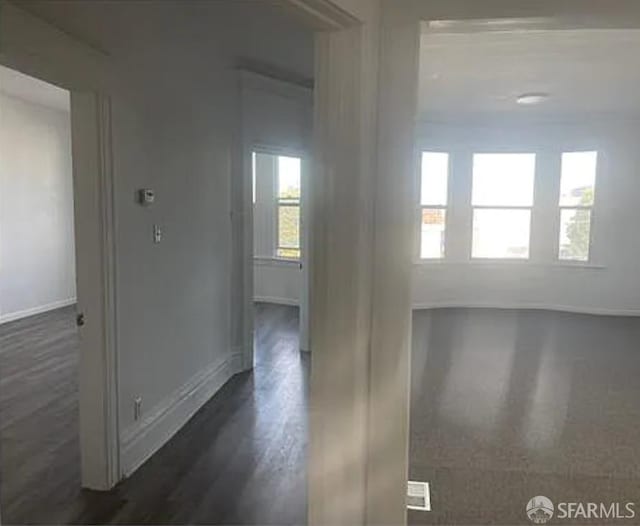 interior space with dark wood-type flooring and baseboards