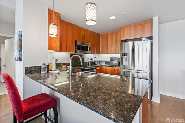 38 N Almaden Blvd Unit 1419, San Jose, CA 95110 - kitchen with stainless steel appliances, a peninsula, brown cabinetry, dark stone countertops, and a sink
