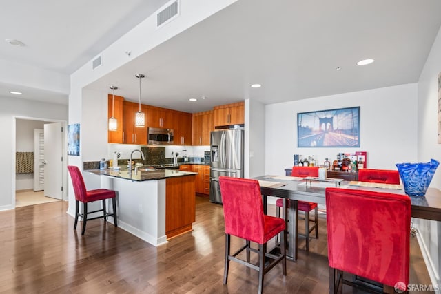 38 N Almaden Blvd Unit 1419, San Jose, CA 95110 - kitchen featuring appliances with stainless steel finishes, brown cabinetry, a peninsula, dark wood-type flooring, and recessed lighting