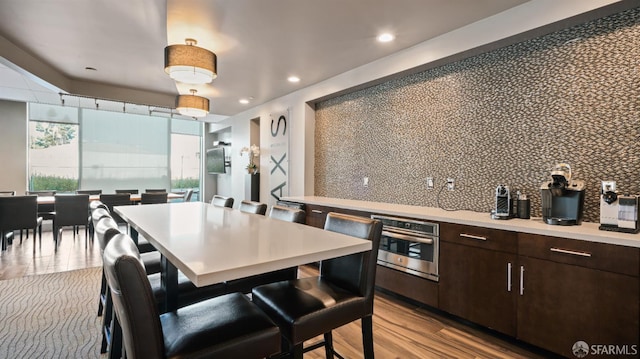 38 N Almaden Blvd Unit 1419, San Jose, CA 95110 - kitchen with oven, tasteful backsplash, dark brown cabinetry, light countertops, and wood finished floors