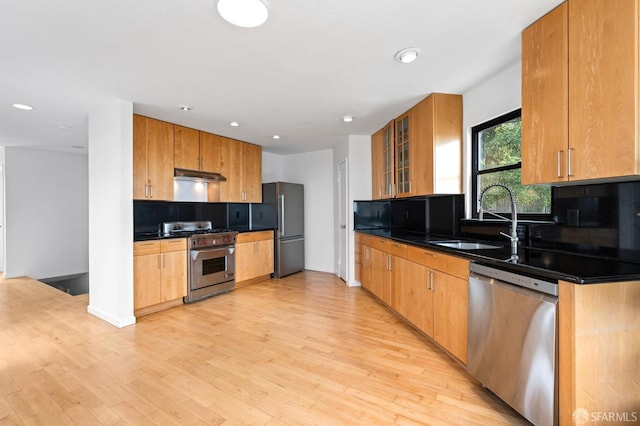 11 Sparta St, San Francisco, CA 94134 - kitchen featuring appliances with stainless steel finishes, a sink, backsplash, under cabinet range hood, and dark countertops