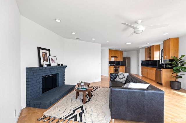 11 Sparta St, San Francisco, CA 94134 - living room with light wood-style floors, a ceiling fan, baseboards, a fireplace, and recessed lighting