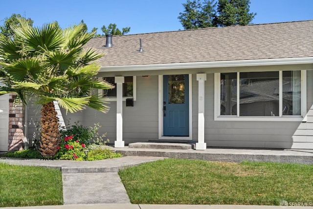 view of exterior entry with a yard