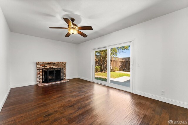 unfurnished living room with dark wood-type flooring, ceiling fan, and a fireplace