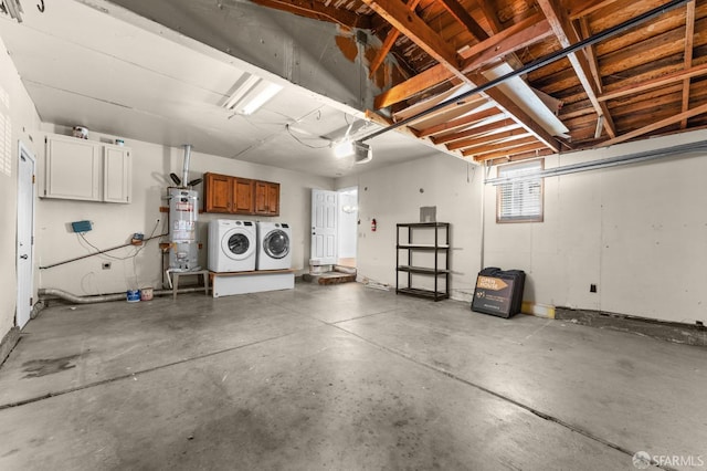 garage featuring washing machine and clothes dryer and secured water heater