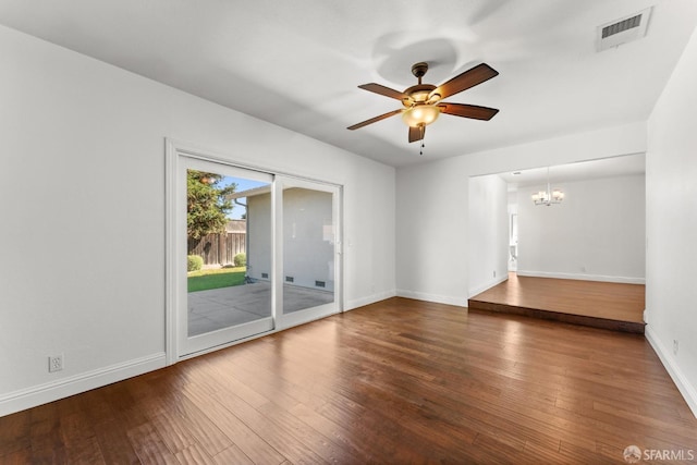 spare room featuring ceiling fan with notable chandelier and wood-type flooring