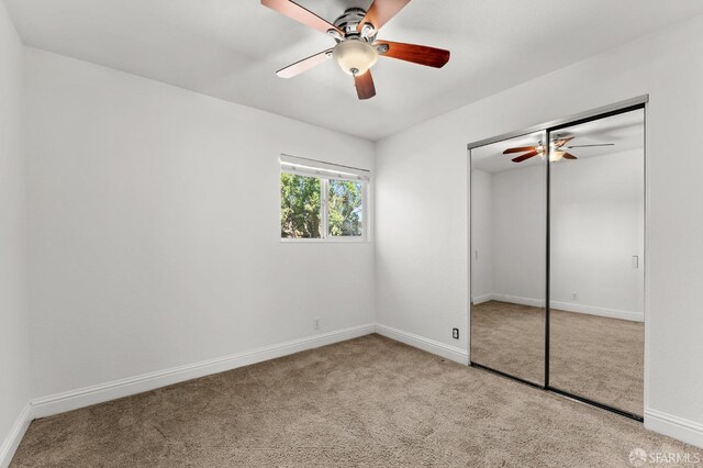 unfurnished bedroom with light carpet, a closet, and ceiling fan