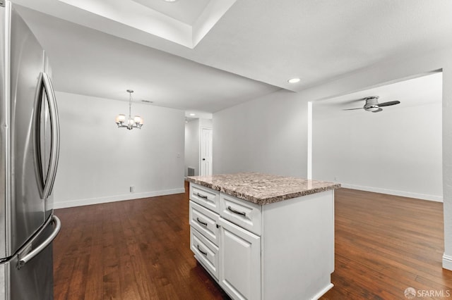 kitchen with white cabinets, a kitchen island, decorative light fixtures, dark wood-type flooring, and stainless steel refrigerator