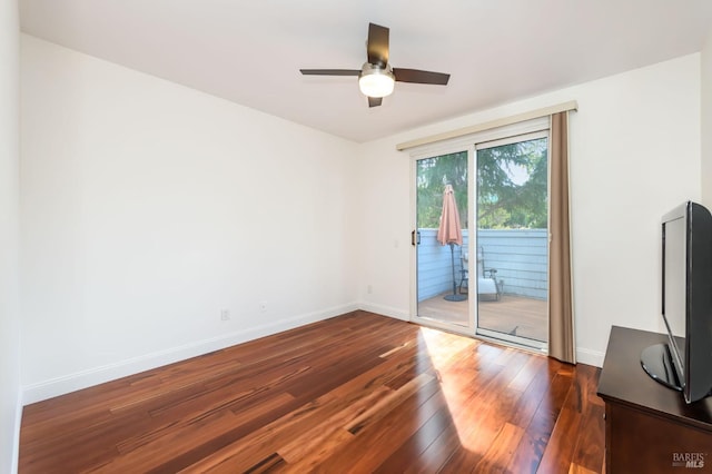 unfurnished room featuring dark wood-type flooring, baseboards, and a ceiling fan