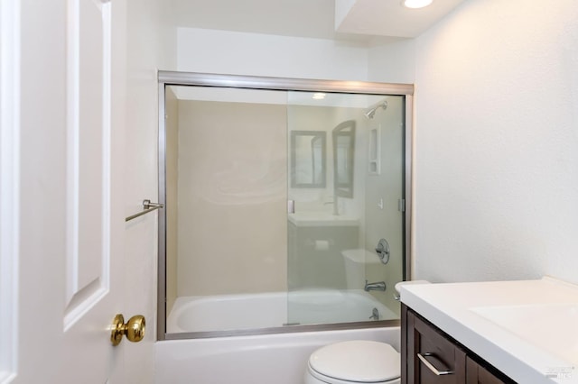 bathroom with enclosed tub / shower combo, vanity, and toilet