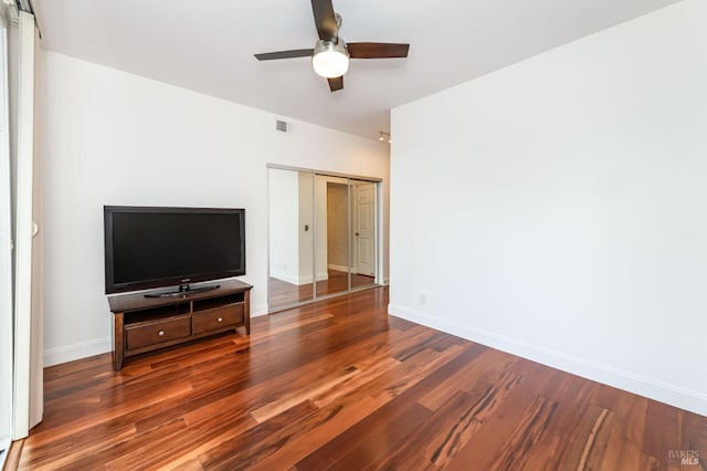 unfurnished living room with dark wood-style floors, ceiling fan, visible vents, and baseboards