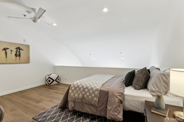 bedroom featuring baseboards, vaulted ceiling, recessed lighting, and wood finished floors